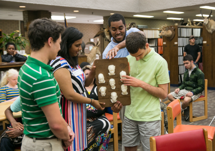 mercer students present a 3D yearbook to a blind student