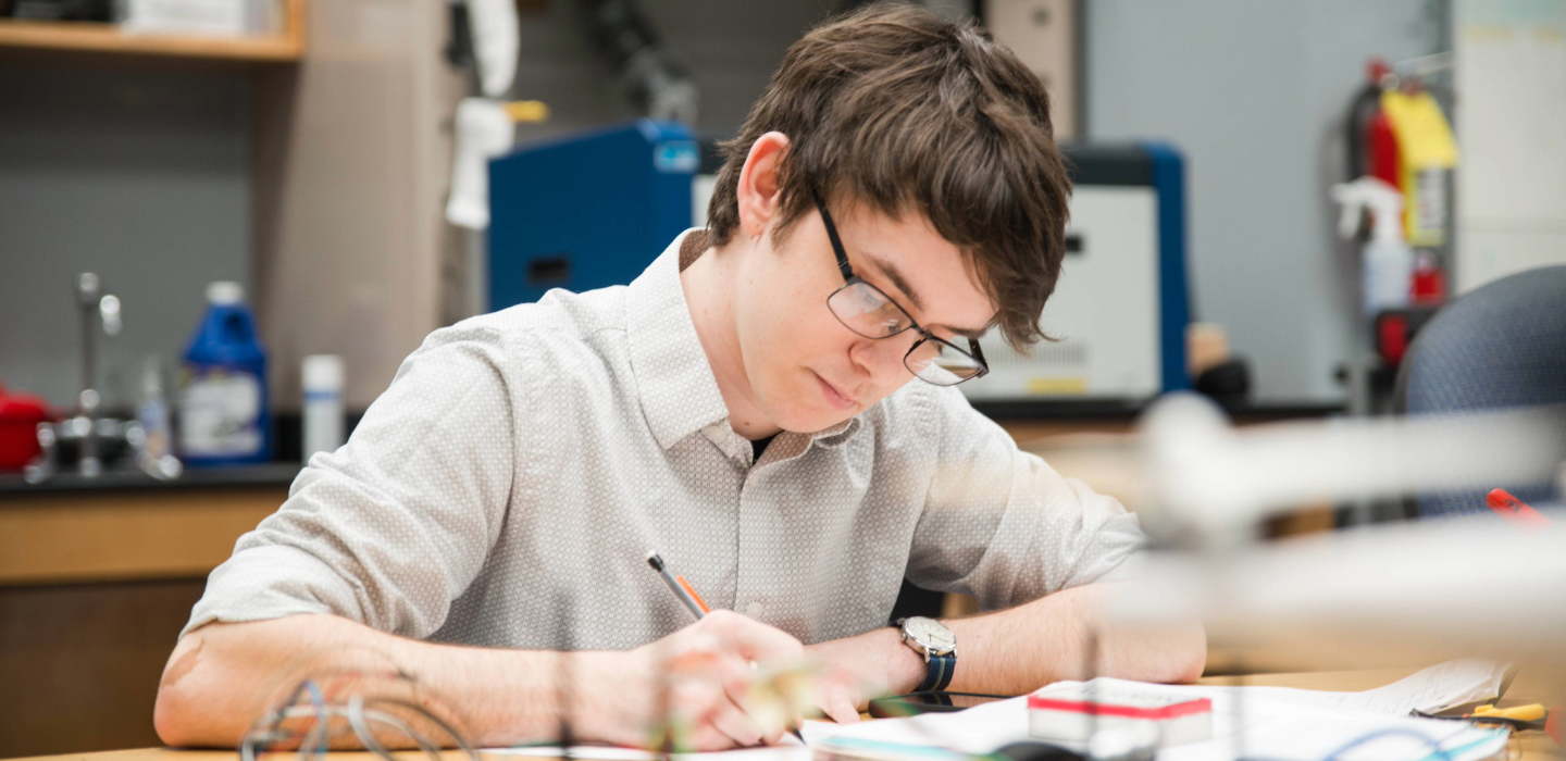 student writing in a notebook